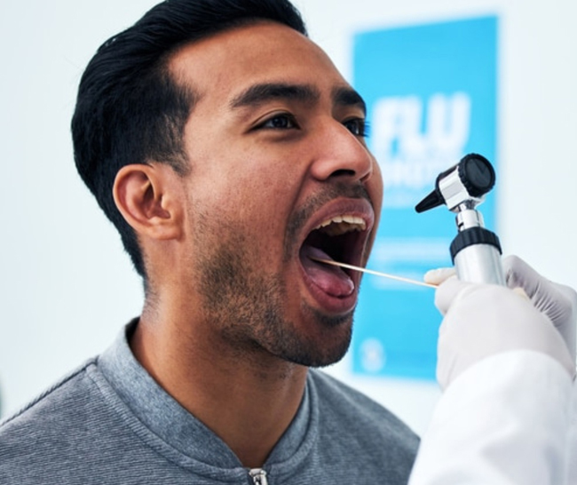 Patient receiving oral examination with intraoral camera at dental office with blue branding.