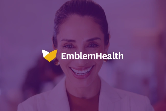 Smiling woman in professional attire with EmblemHealth logo overlay on purple background.
