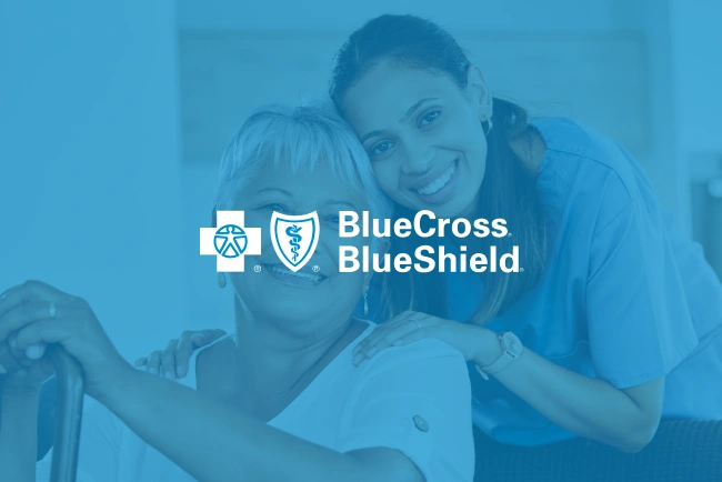 Healthcare provider assisting elderly patient with Blue Cross Blue Shield branding overlay.